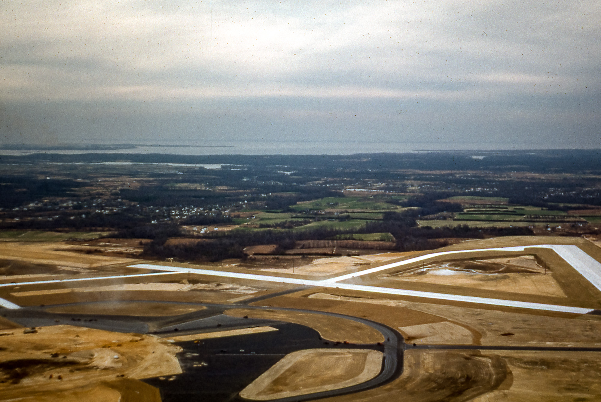 An aerial view of an airport under construction, with runways surrounded by dirt.