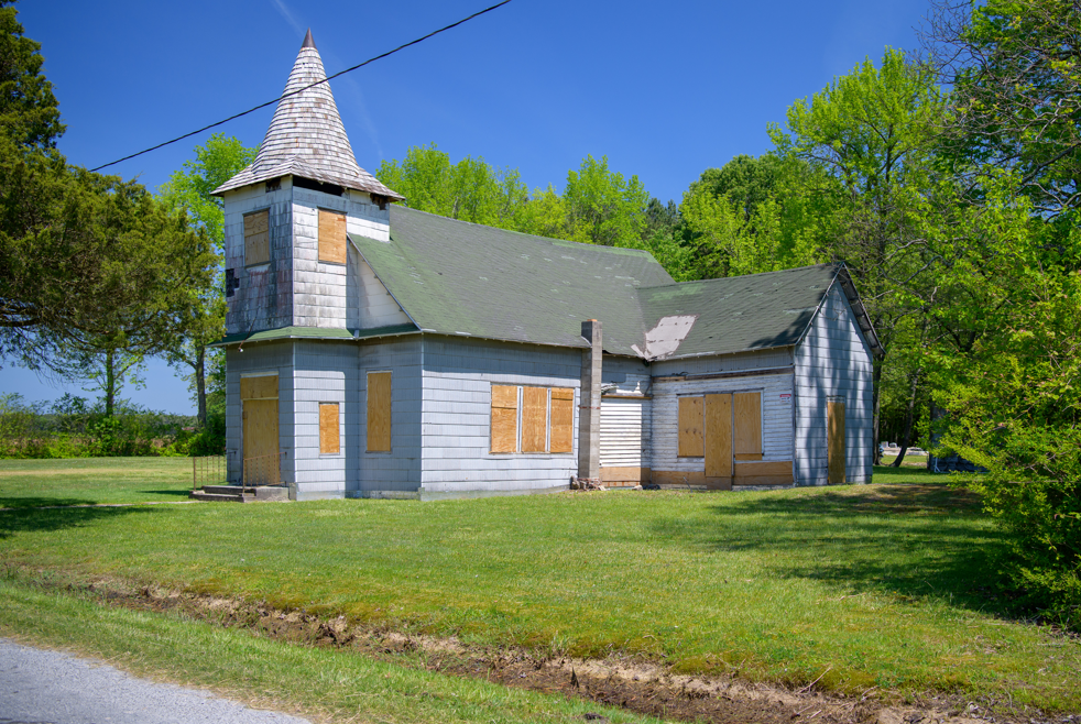 Photo of Malone's Church in Dorchester County with boarded up windows.