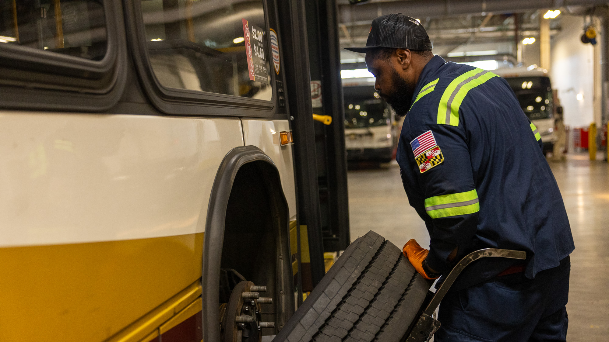 Photo of transit mechanic replacing the wheel on a bus