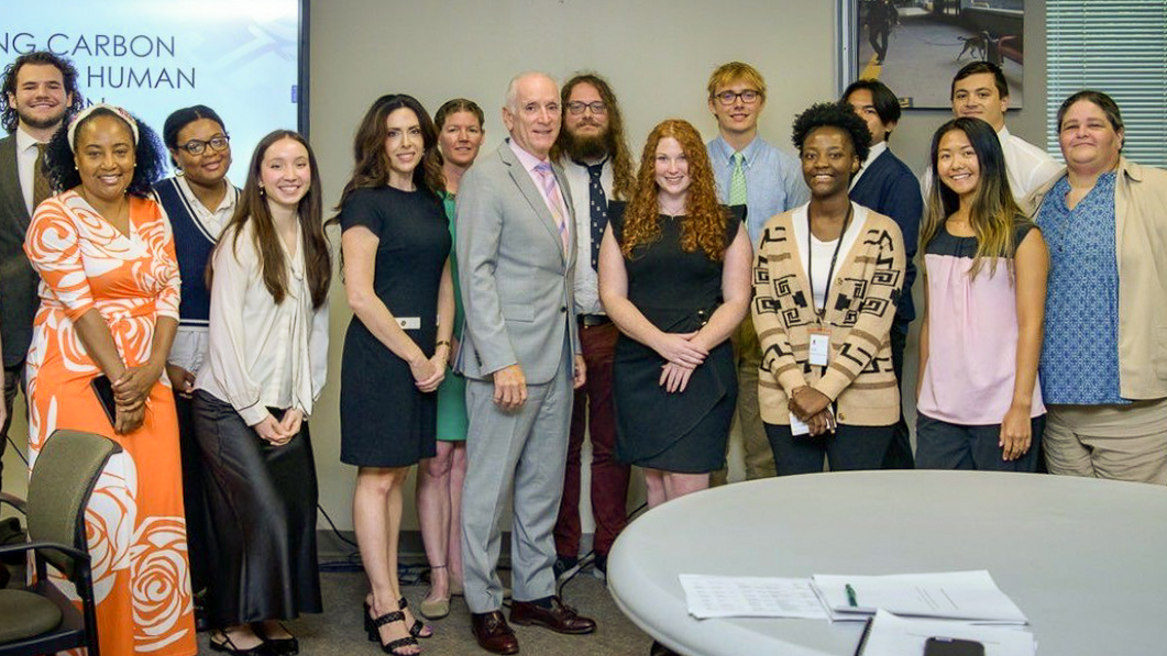 A large group of smiling MDOT Fellows posing indoors alongside MDOT Secretary Paul J. Wiedefeld, celebrating their program milestones.