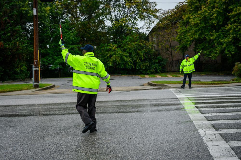 Two crossing guards stopping traffic.